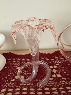 a clear glass vase sitting on top of a table next to a white plate and bowl