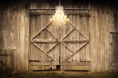 an old barn door with a chandelier hanging from it's center window