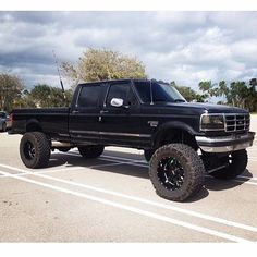 a large black truck parked in a parking lot