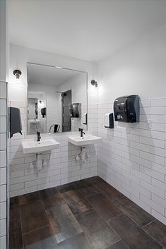 a public restroom with two sinks and three mirrors on the wall, all in black and white