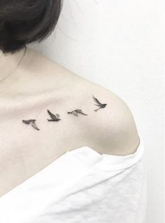 the back of a woman's shoulder with birds on it