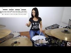 a woman sitting on top of a wooden floor next to a set of drum sticks