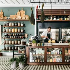 a man standing behind a counter in a store filled with lots of spices and condiments