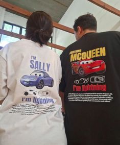 two people wearing matching shirts with cars on them