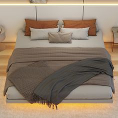 a bed with pillows and blankets on it in the middle of a floored room