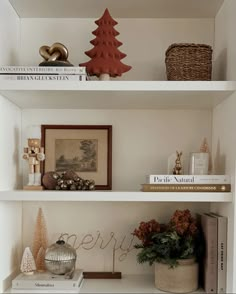 two white shelves with christmas decorations and books