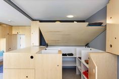 the interior of a tiny house with wooden cabinets and drawers on both sides, including a bed