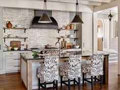 a kitchen with an island and chairs in it