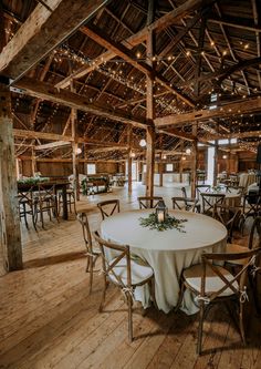 a large room with wooden floors and tables set up for a formal function in the center