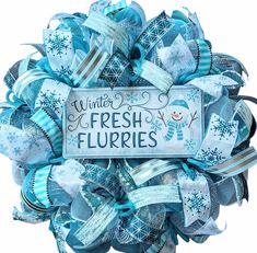 a wreath with blue ribbons and snowflakes on it that says winter fresh flurries