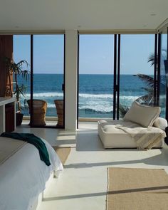 a bedroom with large windows overlooking the ocean