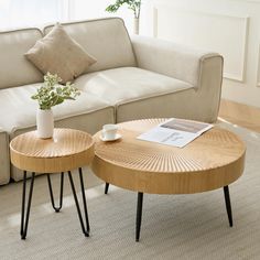 two wooden tables sitting on top of a carpeted floor next to a white couch