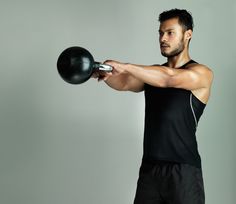 a man in black shirt holding up a ball with one hand and an object on the other