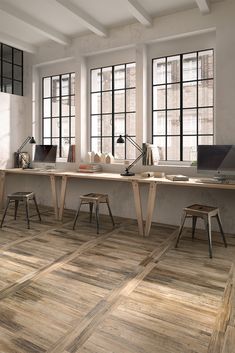 an office with two desks and three chairs in front of large windows that look out onto the street