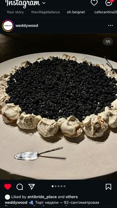 the cake is decorated with blackberries and white icing, on top of a table