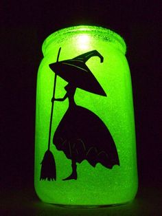 a green jar with a silhouette of a witch holding a broom