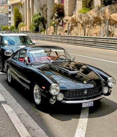 two classic cars parked next to each other on the street