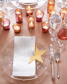 the table is set with silverware, candles, and a star - shaped napkin