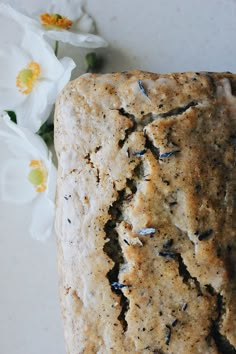 a close up of a piece of bread with flowers in the background