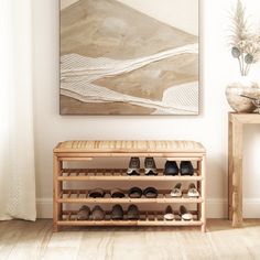 a wooden shoe rack in front of a painting