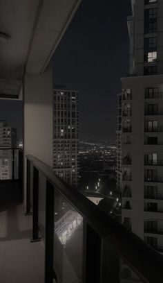 an empty balcony at night overlooking the city lights and skyscrapers in black and white