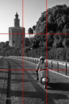 a person riding a scooter on a road with red squares in front of them