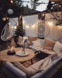 an outdoor living area with wicker furniture and string lights