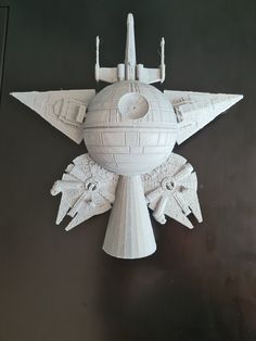 a white model of a star wars ship on top of a black table with other items around it