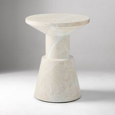 a white marble table sitting on top of a white floor