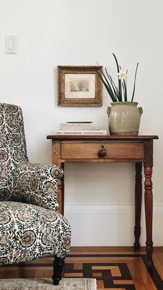 a chair sitting next to a wooden table on top of a hard wood floor