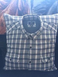 a black and white checkered shirt sitting on top of a pillow