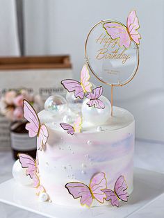 a white cake with pink butterflies on it