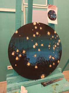 a black plate sitting on top of a blue table next to a painting easel