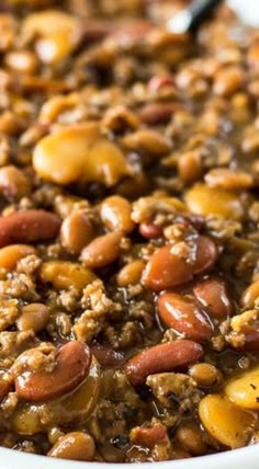 a white bowl filled with beans and meat