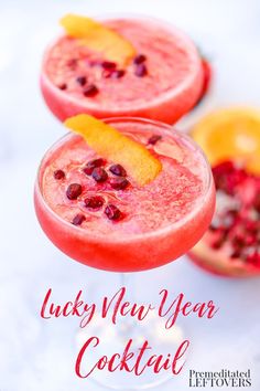 two glasses filled with drinks and garnished with pomegranates