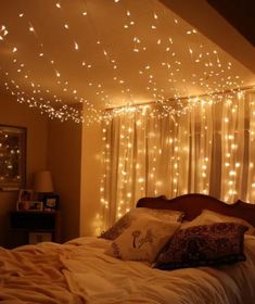 a bed with white lights hanging from the ceiling