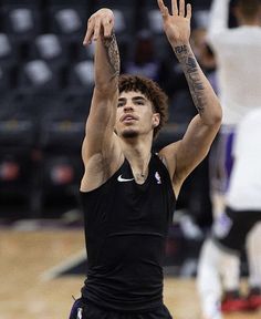 a basketball player is getting ready to hit the ball with his hands and arms in the air