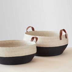 two black and white baskets sitting on top of a table