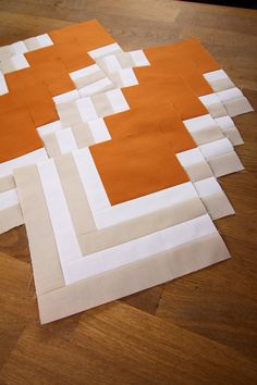 several pieces of fabric are laid out on the floor to be made into quilts