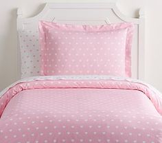 a bed with pink and white hearts on the comforter, pillows and pillow cases