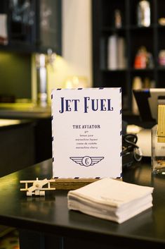 a jet fuel sign sitting on top of a table next to some books and other items