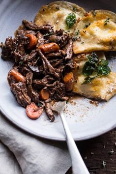 a white plate topped with meat and veggies on top of a wooden table