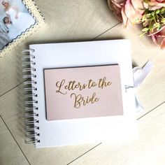 a notepad with the words let's to the bride on it next to flowers