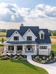 a large white house with lots of windows on it's roof and grass around the front yard