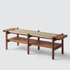 a wooden bench with two benches underneath it on a white background, the bench is made from wood and has a woven seat pad