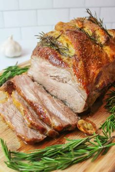 sliced ham on a cutting board with rosemary sprigs