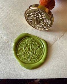 a wax stamp with an image of a tree on it next to a rubber stamp