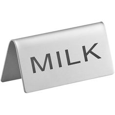 a metal sign with the word milk written in black on it's bottom corner