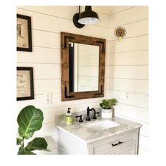 a bathroom with a sink, mirror and pictures on the wall