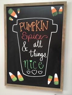 a chalkboard sign with candy corn on it that says pumpkin spice and all things nice